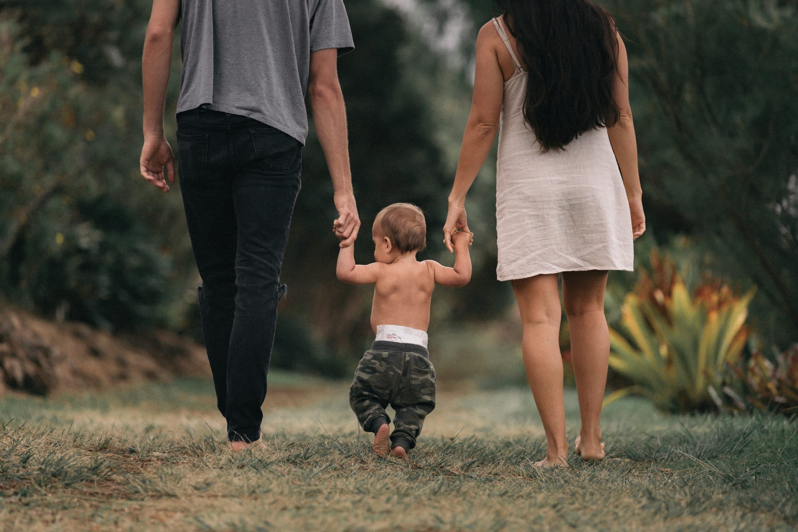 Bébé qui apprend à marcher avec ses parents